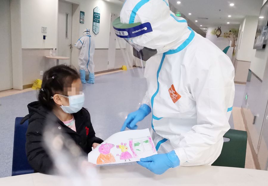 Imagen tomada con un dispositivo móvil del 28 de febrero de 2020 de la enfermera Yang Liu recibiendo un dibujo como un regalo de una ni?a infectada con neumonia del nuevo coronavirus en una sala en el Hospital Infantil de Wuhan, en Wuhan, provincia de Hubei, en el centro de China. (Xinhua)