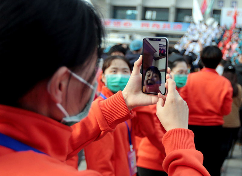 Una trabajadora de la salud transmite en vivo para su hijo la ceremonia de clausura del Hospital Temporal de Wuchang, Wuhan, provincia de Hubei, 10 de marzo del 2020. (Foto: Zhang Zheng/ China Daily)