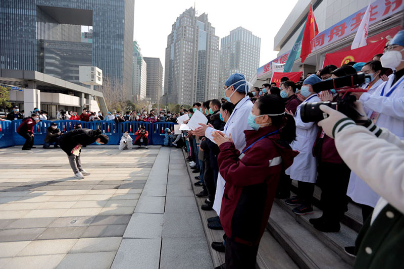 Durante la ceremonia de clausura del Hospital Temporal Wuchang, un paciente ya recuperado presenta sus respetos a los miembros del personal de la salud. Wuhan, provincia de Hubei, 10 de marzo del 2020. (Foto: Zhang Zheng/ China Daily)