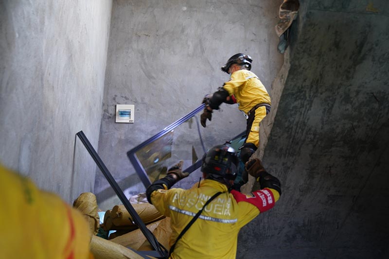 Miembros del equipo de rescate entran en un edificio da?ado en el lugar de la explosión de un camión en Zhejiang. [Foto proporcionada a China Daily]