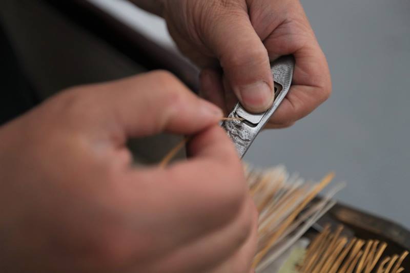 El maestro Wei ordena las "longitudes" para una pintura de papel tejido, condado Zhuanglang, ciudad de Pingliang, provincia de Gansu, 8 de julio del 2020. [Foto: Xinhua]