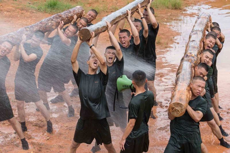 Miembros del escuadrón se ejercitan con troncos de árboles durante un entrenamiento. (Foto: China Daily)