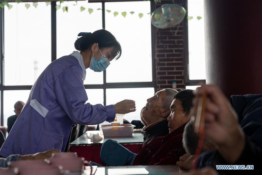 Un trabajador de la salud asiste a un anciano discapacitado en la residencia geriátrica del Hospital Longhui-Weiyuan, condado de Longhui, provincia de Hunan, 12 de octubre del 2020. Para elevar la calidad de la atención al adulto mayor, la unidad geriátrica proporciona servicios de enfermería, rehabilitación, entretenimiento y alimentación. (Fotos: Xinhua)