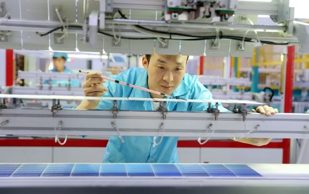 Un trabajador conecta e inspecciona los componentes de las células solares en un taller de una nueva compa?ía de energía en Huzhou, provincia de Zhejiang, en el este de China, el 9 de octubre. Foto de Wang Shucheng / Pueblo en Línea