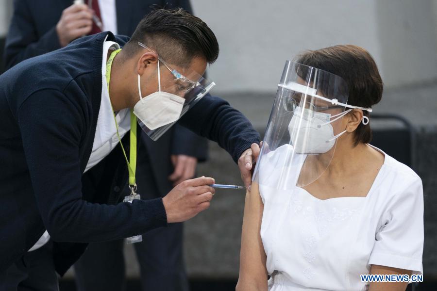 CIUDAD DE MEXICO, 24 diciembre, 2020 (Xinhua) -- Un trabajador de la salud suministra la primera vacuna contra la enfermedad causada por el nuevo coronavirus (COVID-19) en ser aplicada en México, a María Irene Ramírez (d), jefa de Enfermería en la Unidad de Terapia Intensiva del Hospital Rubén Le?ero de la Ciudad de México, en un acto llevado a cabo en el Hospital General de México "Dr. Eduardo Liceaga", en la Ciudad de México, capital de México, el 24 de diciembre de 2020. México inició el jueves la vacunación contra la COVID-19, con la dosis del laboratorio estadounidense Pfizer y su socio alemán BioNTech, dando prioridad a personal médico y de enfermería del país. (Xinhua/Luis Licona)