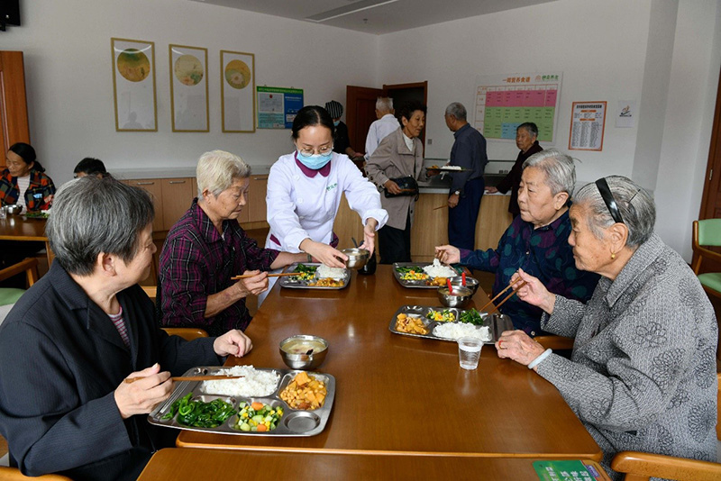 El personal ayuda a una anciana con movilidad reducida a hacer ejercicios de recuperación con bloques de madera para fortalecer la capacidad de agarre de sus dedos en un centro de salud en Nantong, provincia de Jiangsu, en el este de China. (Xu Congjun / Pueblo en Línea)