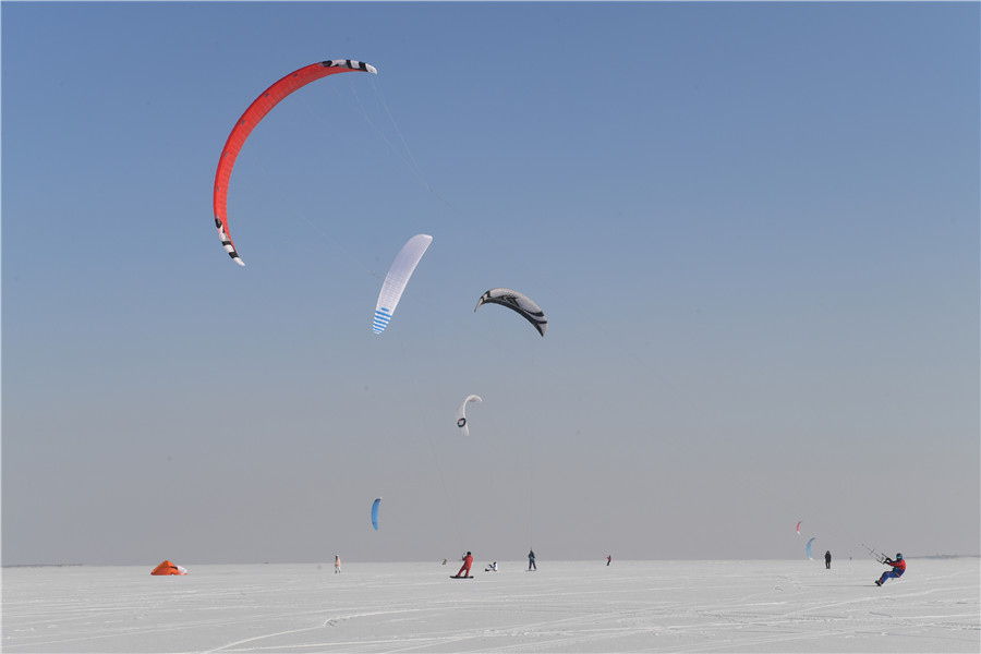 A pesar del frío extremo y los fuertes vientos, más de 30 entusiastas del kitesurfing disfrutaron en el río congelado Songhua de Harbin, provincia de Heilongjiang. La cita de este martes con el esquí y el parapente coincidió con el comienzo del “peque?o frío”, el 23 término solar del calendario.[Foto: Liu Yang/ China Daily]