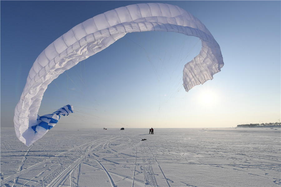 A pesar del frío extremo y los fuertes vientos, más de 30 entusiastas del kitesurfing disfrutaron en el río congelado Songhua de Harbin, provincia de Heilongjiang. La cita de este martes con el esquí y el parapente coincidió con el comienzo del “peque?o frío”, el 23 término solar del calendario.[Foto: Liu Yang/ China Daily]