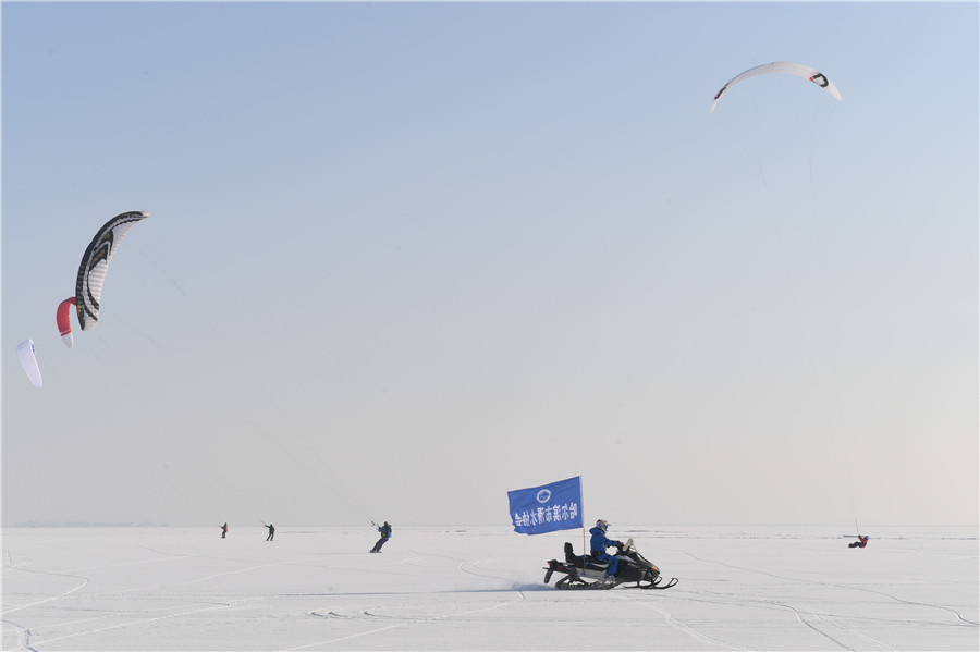 A pesar del frío extremo y los fuertes vientos en el congelado río Songhua en Harbin, provincia de Heilongjiang, los entusiastas del kitesurfing pusieron en una actuación el martes, también el comienzo del 23 término solar “peque?o frío”. [Foto de Liu Yang/para chinadaily.com.cn]