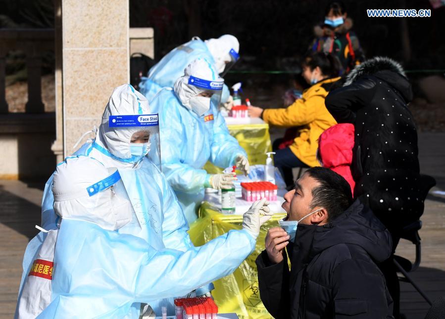 Un trabajador de la salud recoge muestras de hisopo de un residente en un sitio de pruebas en una comunidad del distrito Yuhua, Shijiazhuang, capital de Hebei, 10 de enero del 2021. La segunda ronda de las pruebas de ácido nucleico ha comenzado en algunas comunidades de Shijiazhuang. [Foto: Xinhua]