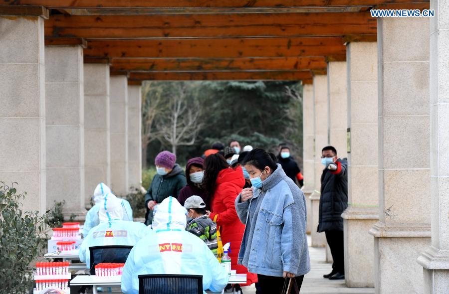 Un trabajador de la salud recoge muestras de hisopo de un residente en un sitio de pruebas en una comunidad del distrito Yuhua, Shijiazhuang, capital de Hebei, 10 de enero del 2021. La segunda ronda de las pruebas de ácido nucleico ha comenzado en algunas comunidades de Shijiazhuang. [Foto: Xinhua]