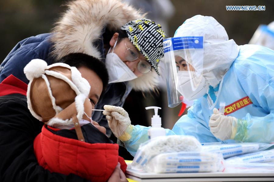 Un trabajador de la salud recoge muestras de hisopo de un residente en un sitio de pruebas en una comunidad del distrito Yuhua, Shijiazhuang, capital de Hebei, 10 de enero del 2021. La segunda ronda de las pruebas de ácido nucleico ha comenzado en algunas comunidades de Shijiazhuang. [Foto: Xinhua]