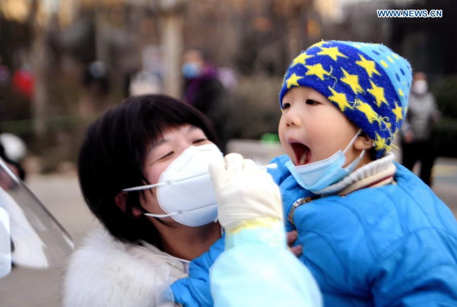 Un trabajador de la salud recoge muestras de hisopo de un residente en un sitio de pruebas en una comunidad del distrito Yuhua, Shijiazhuang, capital de Hebei, 10 de enero del 2021. La segunda ronda de las pruebas de ácido nucleico ha comenzado en algunas comunidades de Shijiazhuang. [Foto: Xinhua]