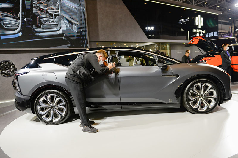 Un hombre hace fotos de un vehículo de nueva energía en una exhibición de coches en Haikou, provincia de Hainan, en el sur de China, el 8 de enero de 2021. [Foto / Xinhua]