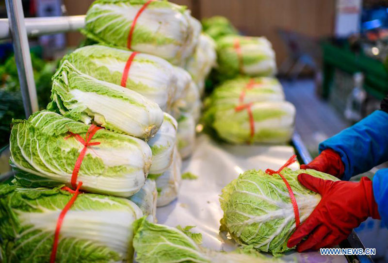 Un miembro del personal ordena las verduras en un supermercado en el distrito Dongchang en Tonghua, provincia de Jilin, noreste de China, el 24 de enero de 2021. 