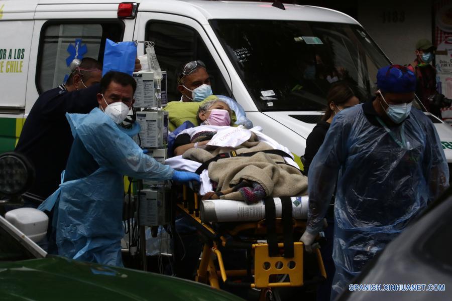 Personal médico evacúa a una paciente durante un incendio en el Hospital San Borja, en Santiago, capital de Chile, el 30 de enero de 2021. La Oficina Nacional de Emergencia de Chile reportó el sábado un incendio en el Hospital San Borja, ubicado en el centro de la capital, que obligó a evacuar a pacientes críticos, aunque no se registraron heridos. (Xinhua/Str)