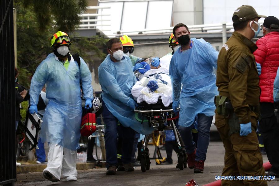 Personal médico evacúa a un paciente durante un incendio en el Hospital San Borja, en Santiago, capital de Chile, el 30 de enero de 2021. La Oficina Nacional de Emergencia de Chile reportó el sábado un incendio en el Hospital San Borja, ubicado en el centro de la capital, que obligó a evacuar a pacientes críticos, aunque no se registraron heridos. (Xinhua/Str)