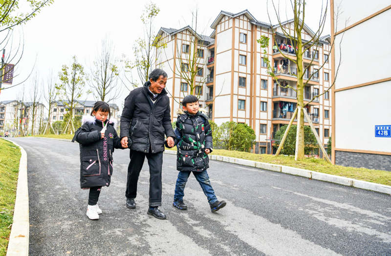 Li Changde camina con los ni?os después de recogerlos en la escuela de una comunidad de nueva construcción que forma parte del programa de alivio a la pobreza en la antigua ciudad de Shexiang, Dafang, Guizhou, 23 de diciembre del 2020.