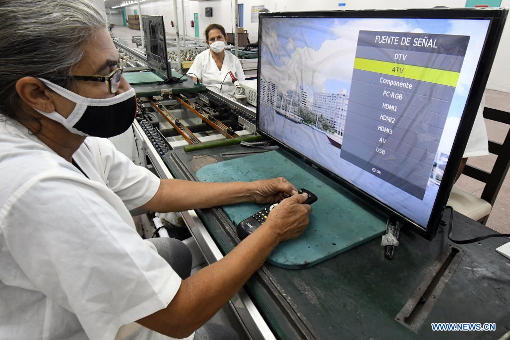 Imagen del 21 de mayo de 2021 de una trabajadora revisando el estado técnico de un televisor ensamblado en los talleres de la Empresa Industria Electrónica "Comandante Camilo Cienfuegos", en La Habana, capital de Cuba. Cuba espera dar un impulso a la expansión de la televisión digital con norma china mediante la producción este a?o de 318.000 cajas decodificadoras, en el contexto de la pandemia de la enfermedad del nuevo coronavirus (COVID-19) y los efectos de las sanciones económicas del bloqueo de Estados Unidos contra el país. (Xinhua/Joaquín Hernández)