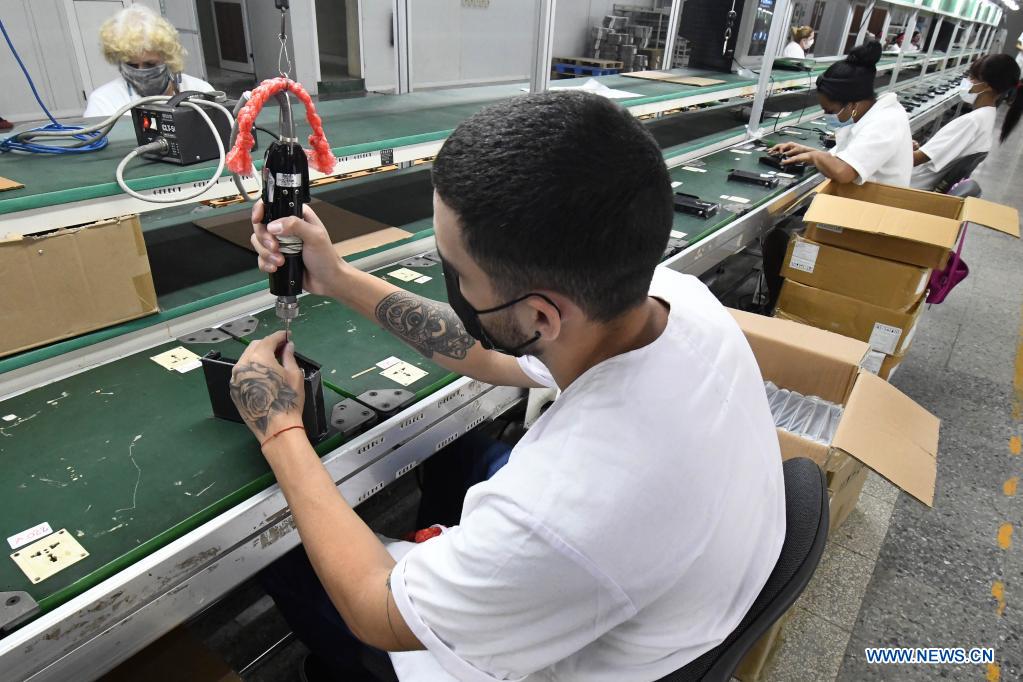 Imagen del 21 de mayo de 2021 de trabajadores ensamblando cajas decodificadoras usadas para la televisión digital con norma china en los talleres de la Empresa Industria Electrónica "Comandante Camilo Cienfuegos", en La Habana, capital de Cuba. Cuba espera dar un impulso a la expansión de la televisión digital con norma china mediante la producción este a?o de 318.000 cajas decodificadoras, en el contexto de la pandemia de la enfermedad del nuevo coronavirus (COVID-19) y los efectos de las sanciones económicas del bloqueo de Estados Unidos contra el país. (Xinhua/Joaquín Hernández)