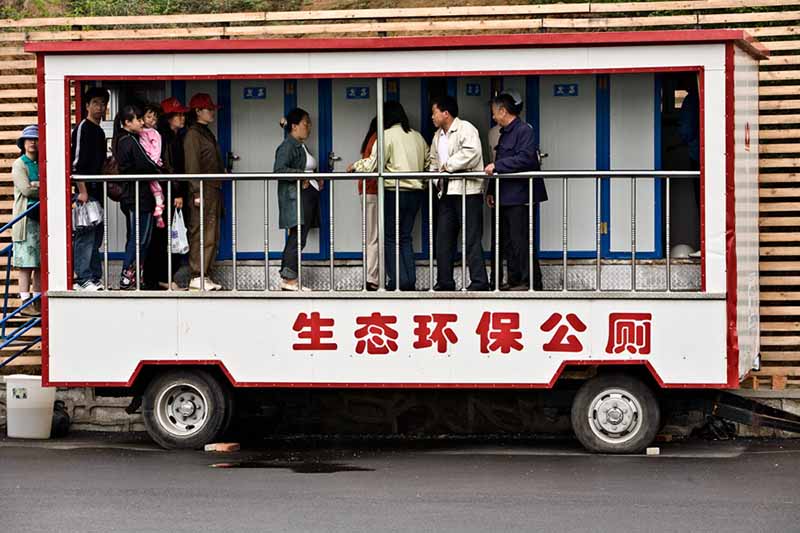 Los visitantes de la Exposición Mundial de Horticultura hacen fila para ir al ba?o en un "ba?o público ecológico" móvil en Shenyang, Liaoning, el 21 de mayo de 2006. [Foto proporcionada a China Daily]