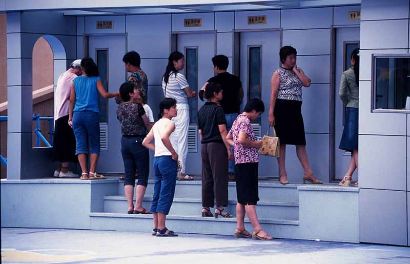 Personas hacen fila frente a los ba?os temporales en Shenyang, provincia de Liaoning, en el noreste de China, el 2 de julio de 2005. [Foto proporcionada a China Daily]