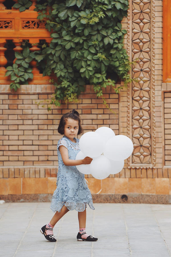 Una ni?a Uygur juega con globos a lo largo de una calle en el casco antiguo de Tuancheng, la ruta peatonal más famosa de la ciudad de Hotan, en la región autónoma Uygur de Xinjiang, noroeste de China, el 22 de mayo de 2021 (Pueblo en Línea / Yuan Meng).