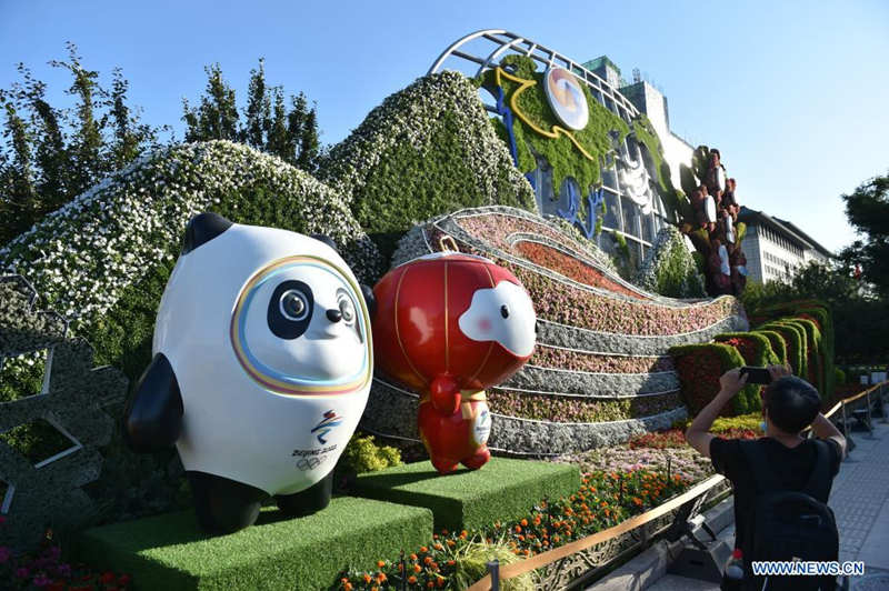 Un hombre toma fotos de las decoraciones florales que embellece la capitalina avenida Chang'an, 19 de junio del 2021. [Foto: Xinhua]