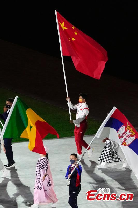 El velocista chino Su Bingtian camina por el Estadio Olímpico con la bandera nacional de China durante la ceremonia de clausura de los Juegos Olímpicos de Tokio 2020 en Japón, el 8 de agosto de 2021 (Foto: China News Service / Du Yang).