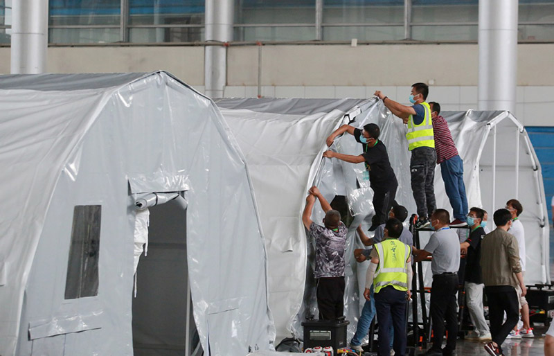 Los miembros del personal instalan un laboratorio de pruebas inflable "Falcon" para las pruebas de ácido nucleico de COVID-19 en el Centro Internacional de Exposiciones de Yangzhou, provincia de Jiangsu, en el este de China, el 10 de agosto de 2021. [Foto de Meng Delong / para China Daily]