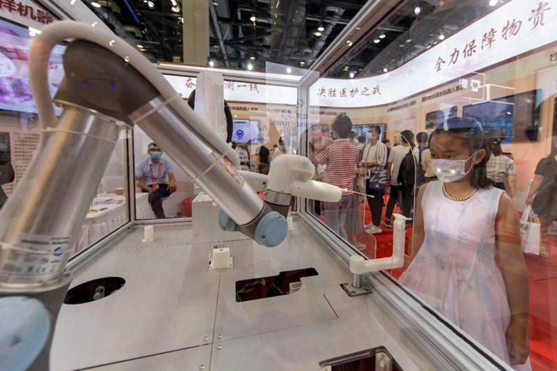 Un ni?o observa un robot de muestreo de hisopo de garganta en la Feria Internacional de Comercio de Servicios de China, Beijing, 6 de septiembre del 2020. (Foto: Pueblo en Línea/ Weng Qiyu)