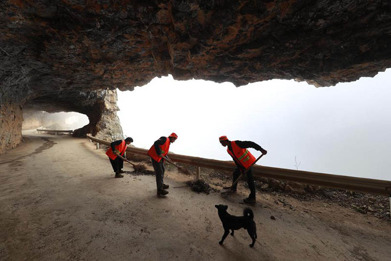 Los residentes revisan y limpian su camino construido a mano a lo largo de 470 metros de acantilados en la aldea de Shibanhe del condado Hezhang, provincia de Guizhou. [Foto de Han Xianpu / para chinadaily.com.cn]