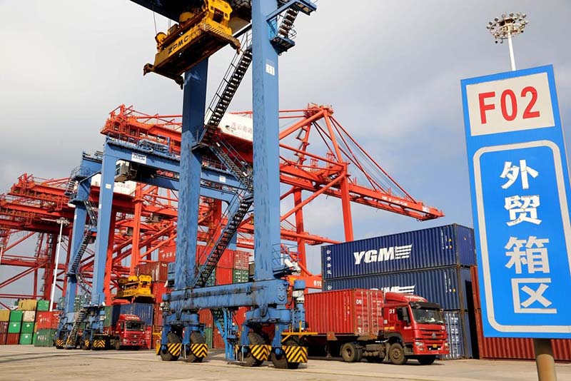 La foto tomada el 13 de octubre del 2021 muestra vehículos que transfieren contenedores a un buque de carga en una terminal de contenedores del puerto de Lianyungang, provincia de Jiangsu. (Foto: Wang Chun/ Pueblo en Línea)