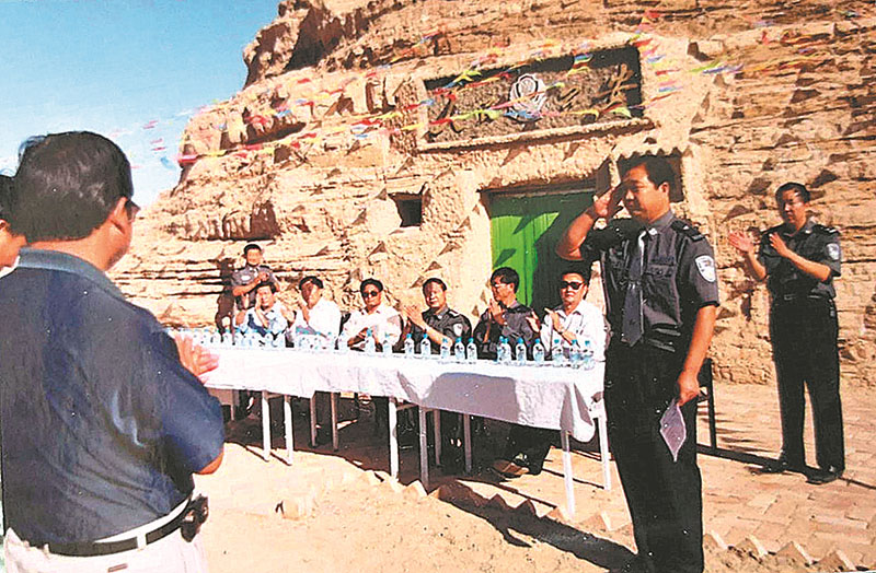 Li Shengshou y sus compa?eros en una ceremonia para conmemorar la finalización de la comisaría de policía de la cueva en el Geoparque Nacional Yardang de Dunhuang, provincia de Gansu, en 2003. Foto proporcionada a CHINA DAILY