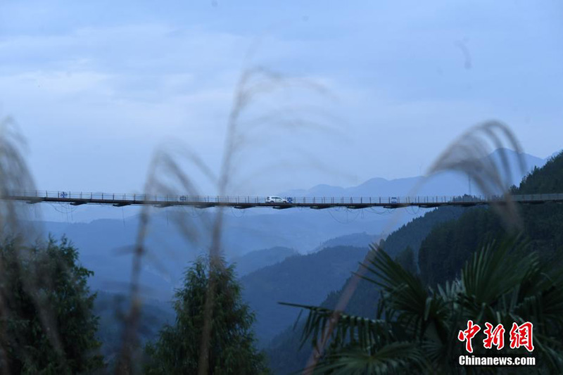 El 17 de diciembre, un vehículo pasó por un puente colgante en las monta?as del distrito Wulong, ciudad de Chongqing.