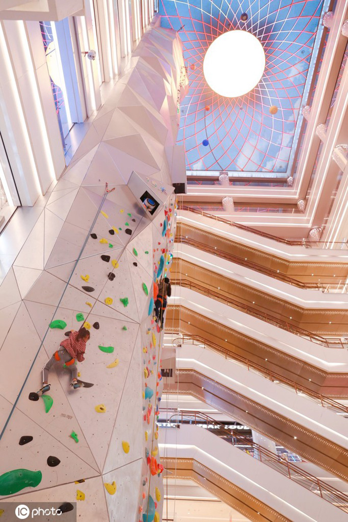 Los entusiastas de los deportes extremos experimentan la escalada en roca en un centro comercial de Shanghai, 19 de diciembre del 2021. [Foto: IC]