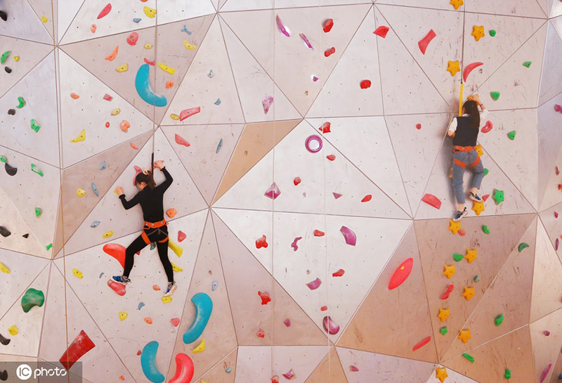 Los entusiastas de los deportes extremos experimentan la escalada en roca en un centro comercial de Shanghai, 19 de diciembre del 2021. [Foto: IC]