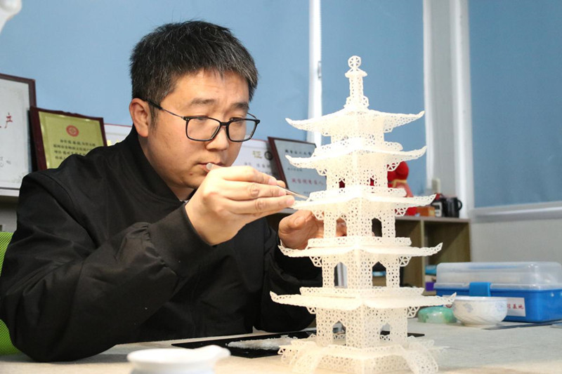 El artista popular Chen Guorui hace una pagoda usando alrededor de 12 500 granos de arroz. [Foto proporcionada a chinadaily.com.cn]