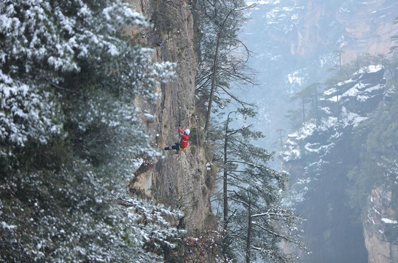 Durante una sesión de entrenamiento, miembros del equipo de rescate de emergencia se ofrecieron como voluntarios para recoger basura en rocas y acantilados del sitio turístico Wulingyuan de Zhangjiajie, provincia de Hunan, febrero del 2022. [Foto: Wu Yongbing/ China Daily]