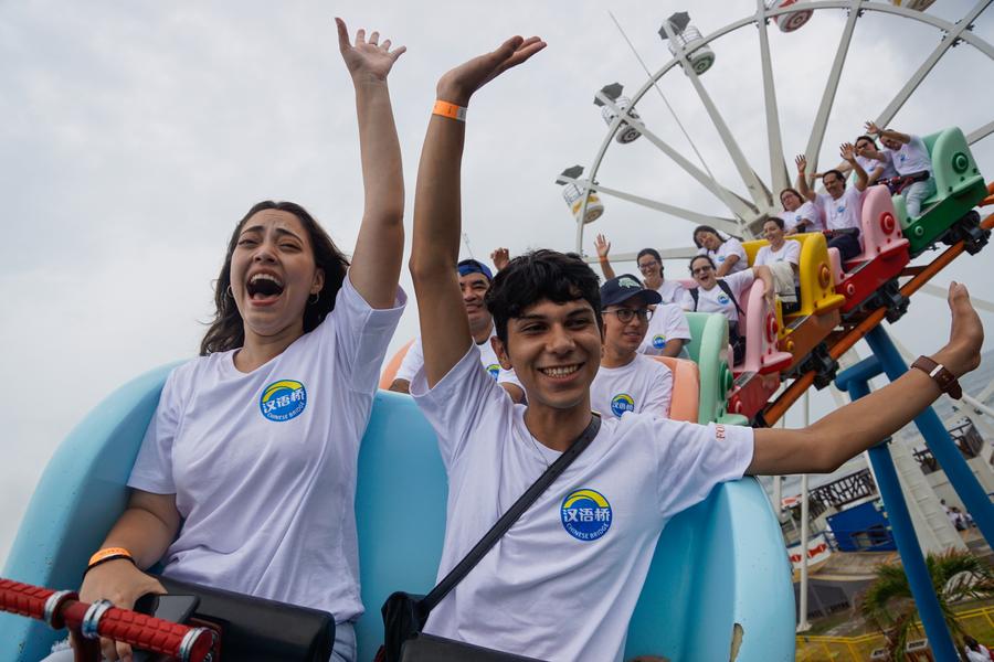 Imagen del 7 de junio de 2023 de alumnos del Instituto Confucio de la Universidad de El Salvador disfrutando de un juego mecánico de Sunset Park durante un recorrido por los proyectos con asistencia china días antes del primer concurso internacional Puente Chino para estudiantes universitarios en El Salvador, en el departamento de La Libertad, El Salvador. (Xinhua/Alexander Pe?a)