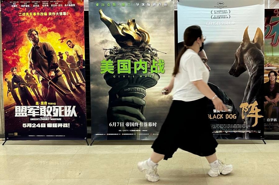 Una mujer pasa caminando frente a carteles de películas en un cine de Beijing, la capital de China, el 7 de junio de 2024. (Xinhua/Shen Anni)