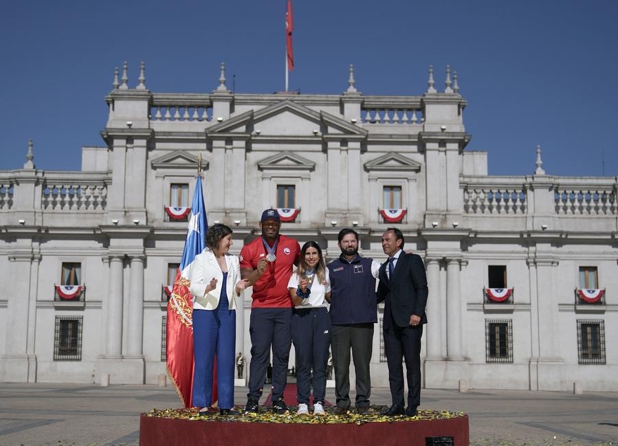 Imagen cedida por la Presidencia de Chile del presidente chileno, Gabriel Boric (2-d), y los medallistas en los Juegos Olímpicos de París 2024, Francisca Crovetto (c), y Yasmani Acosta (2-i), posando para una fotografía durante un homenaje en el Palacio de La Moneda, en Santiago, capital de Chile, el 12 de agosto de 2024. (Xinhua/Presidencia de Chile)