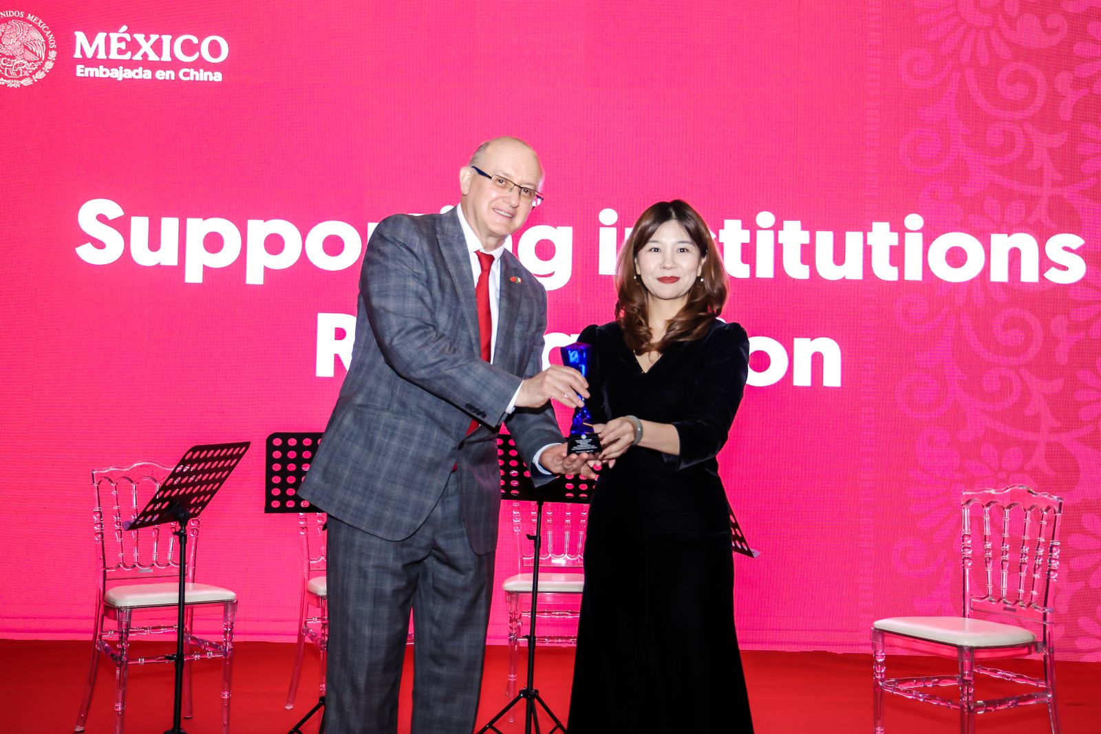 Enrique Escamilla, ministro y jefe de Cancillería de la Embajada de México en China, entrega un reconocimiento a Wei Huan, directora del Centro Internacional de Intercambio Cultural YWHY, durante el Encuentro anual del Grupo de Esposas de Jefes de Misiones Diplomáticas, Salón Cocoon del Hotel Eclait, Beijing, 24 de octubre del 2024. (Foto: cortesía)