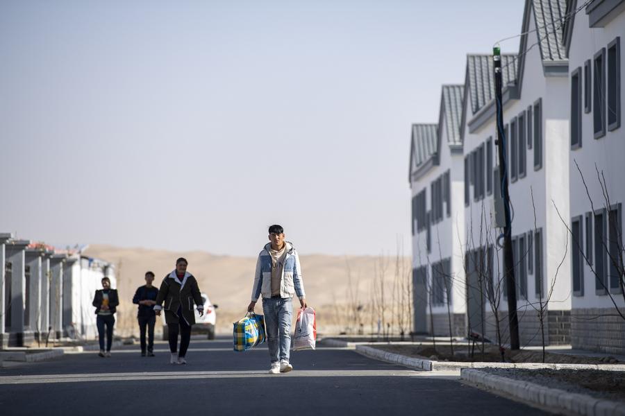 Imagen del 19 de noviembre de 2019 de personas caminando en una calle en un sitio de reasentamiento de vivienda para los aldeanos del poblado de Darya Boyi en el distrito de Yutian, en la región autónoma de la etnia uygur de Xinjiang, en el noroeste de China. (Xinhua/Hu Huhu) 