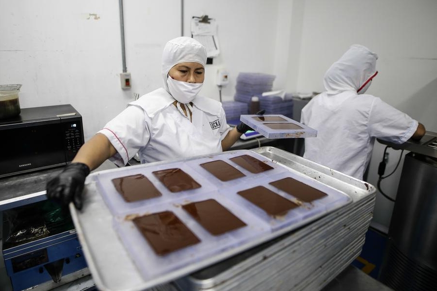 Imagen del 12 de octubre de 2023 de personas trabajando en la producción de chocolates en la fábrica de la empresa L?k Foods, en Bogotá, Colombia. (Xinhua/Str) 