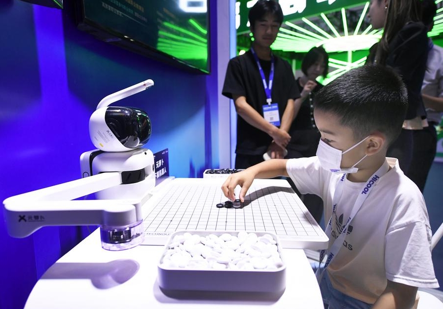 Imagen del 24 de agosto de 2024 de un ni?o jugando ajedrez con un robot en el área de exposiciones de la Cumbre Global de Emprendedores HICOOL 2024, en Beijing, capital de China. (Xinhua/Ren Chao) 