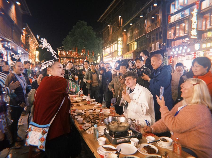 El bloguero alemán Robert Adolf (segundo por la derecha) y su madre, Anna Adolf (primera por la derecha), participan en una celebración del A?o Nuevo dong en el poblado de la etnia dong de Zhaoxing, en el distrito de Liping de la provincia de Guizhou, en el suroeste de China, el 30 de noviembre de 2024. (Xinhua/Zhou Xuanni)