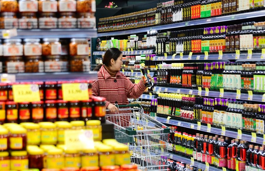 Una clienta selecciona condimentos en un supermercado en Wuxi, en la provincia oriental china de Jiangsu, el 9 de diciembre de 2024. (Xinhua/Huan Yueliang)