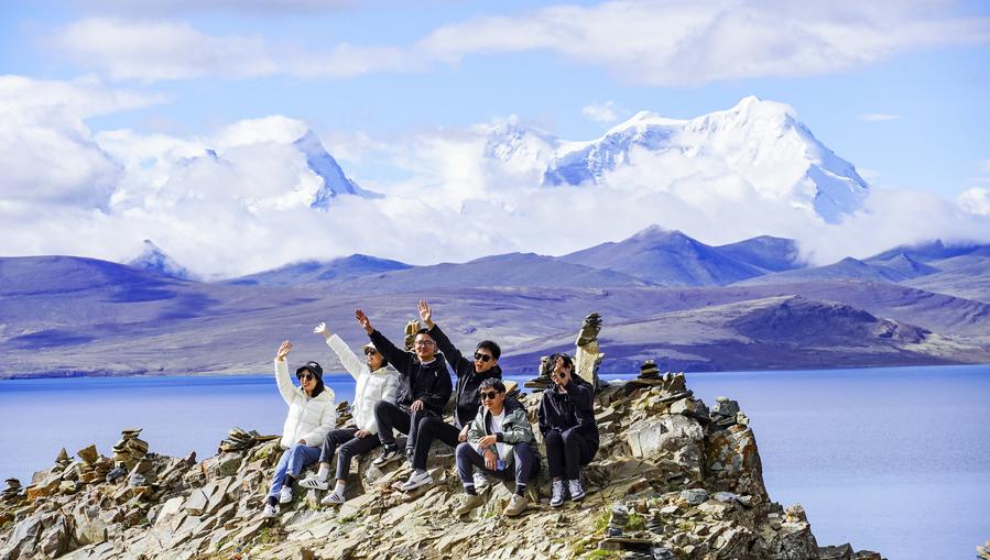 Turistas posan para fotos en el lago Puma Yumco, ubicado en el distrito de Nagarze de Shannan, región autónoma de Xizang, suroeste de China, el 4 de julio de 2023. (Xinhua/Chen Shangcai). 