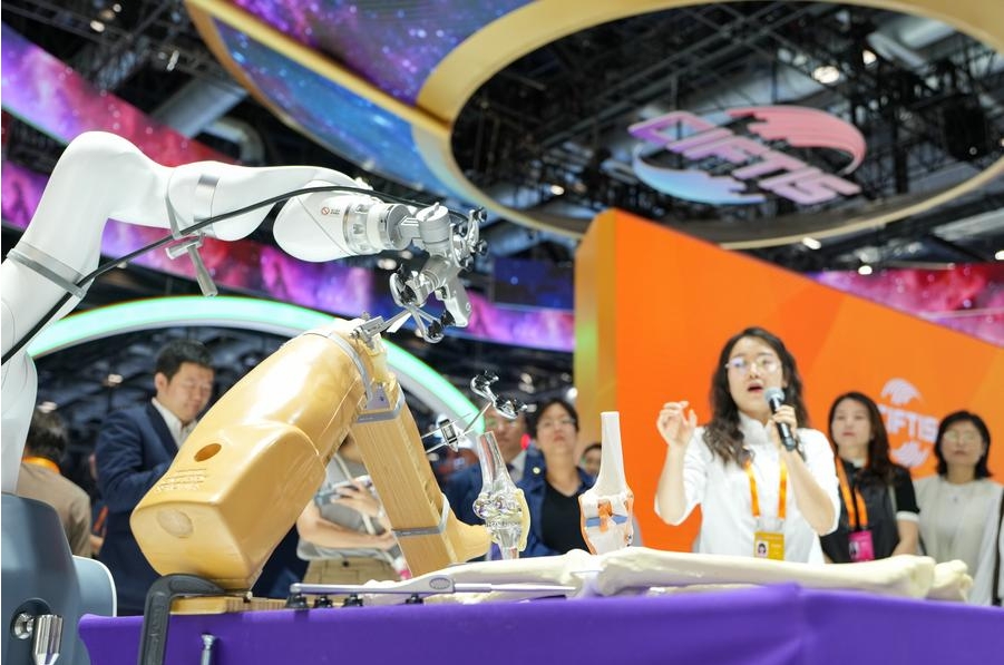 Visitantes observan un robot quirúrgico ortopédico impulsado por inteligencia artificial durante la Feria Internacional de Comercio de Servicios de China (CIFTIS, siglas en inglés) 2024, en el Centro Nacional de Convenciones de China, en Beijing, la capital, el 13 de septiembre de 2024. (Xinhua/Ju Huanzong)